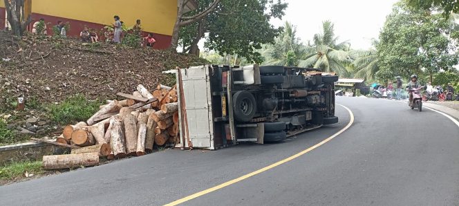 
					Overload, Truk Bermuatan Kayu di Pangandaran Terguling